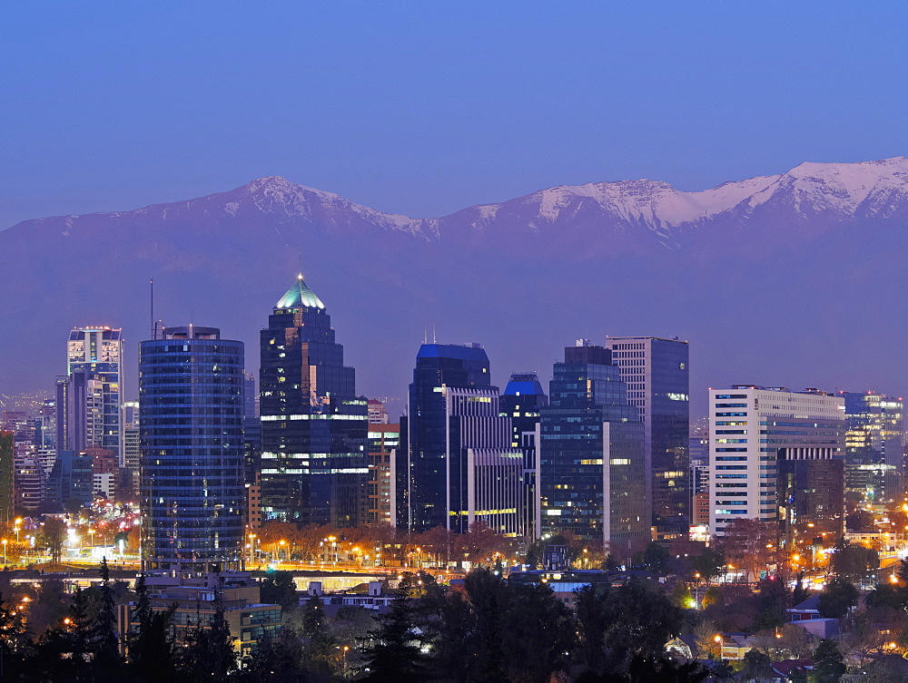 Twilight view from the Parque Metropolitano towards the high rise buildings in the financial sector, and snow covered mountains behind, Santiago, Chile, South America