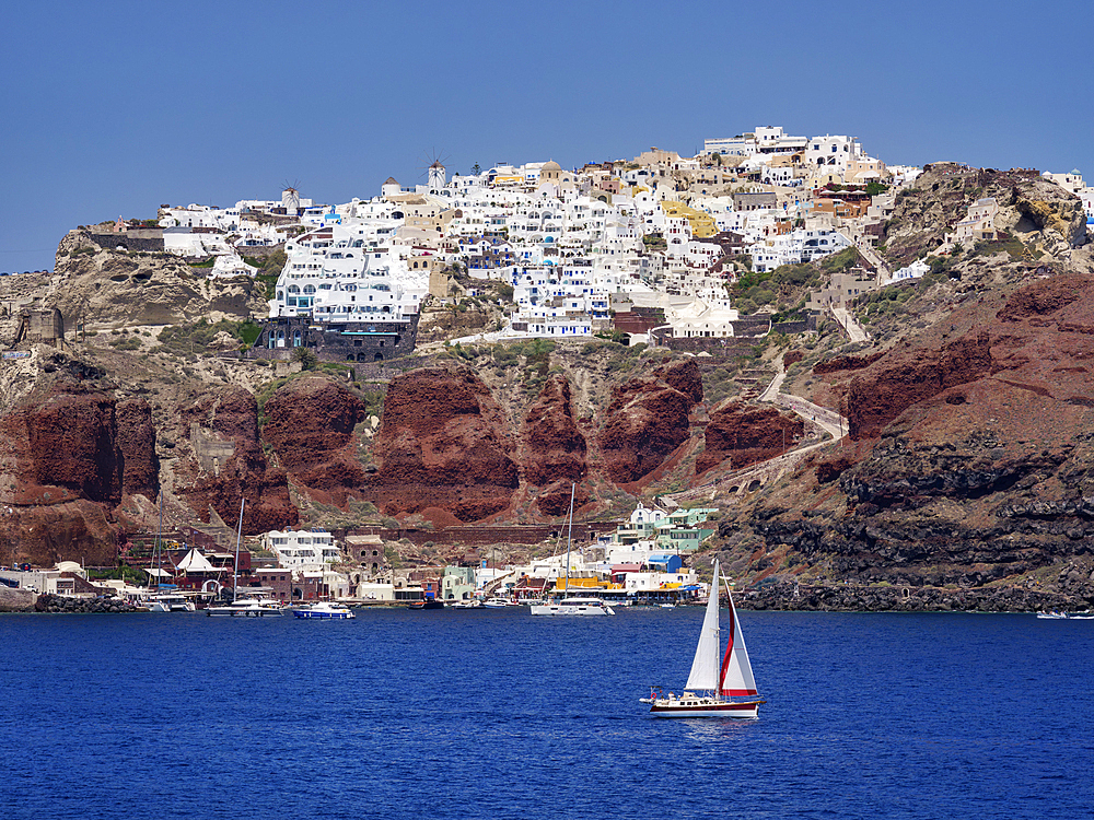 Sailboat in the caldera and Oia Village, Santorini (Thira) Island, Cyclades, Greek Islands, Greece, Europe