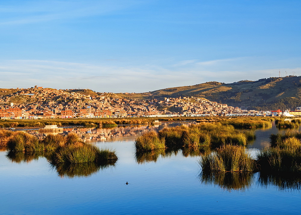 Lake Titicaca and cityscape of Puno at sunrise, Peru, South America