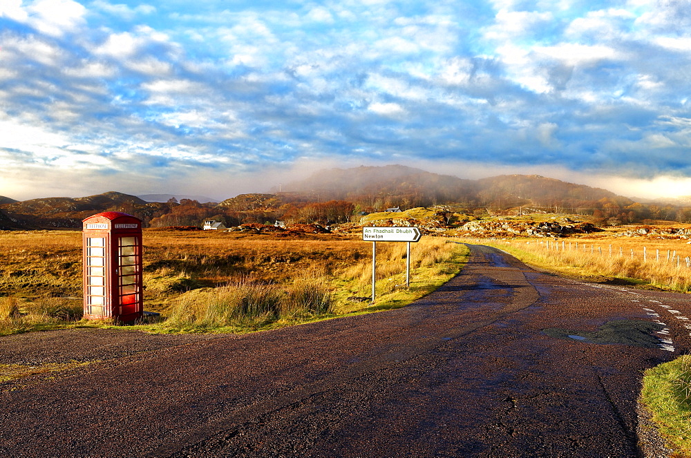 Autumn view of a red telephone box at the side of a quiet road in the remote misty Ardnamurchan moors of the Scottish Highlands, Scotland, United Kingdom, Europe