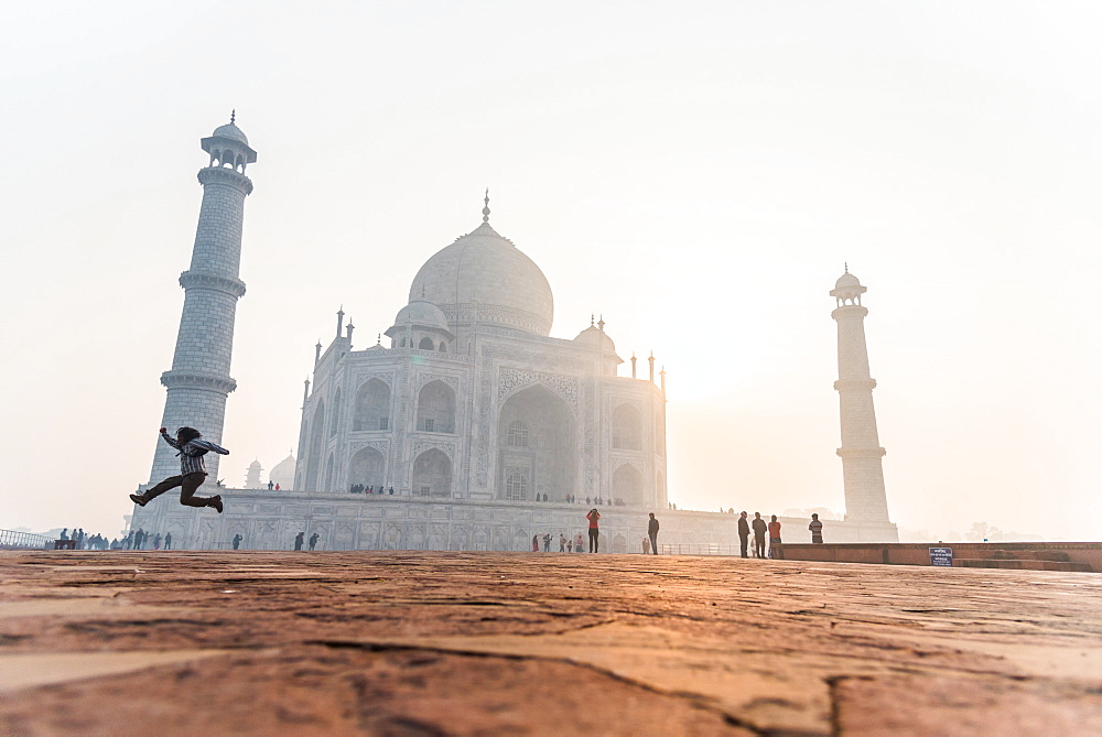 A man jumps as the sun rises behind the Taj Mahal, UNESCO World Heritage Site, Agra, Uttar Pradesh, India, Asia