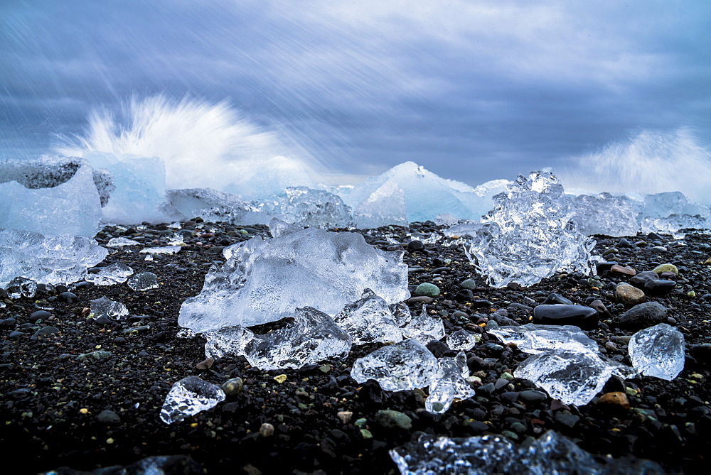 Water crashing over the ice and black sandy beach at Jokulsarlon, Iceland, Polar Regions