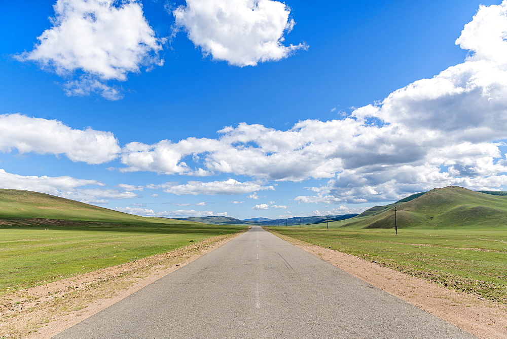 Straight road in the Mongolian steppe and clouds in the sky, North Hangay province, Mongolia, Central Asia, Asia