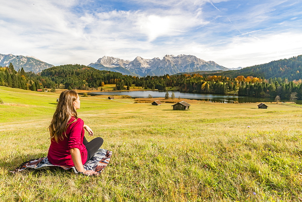 Woman sitting and staring at Gerold lake and Karwendel Alps, Krun, Upper Bavaria, Bavaria, Germany, Europe