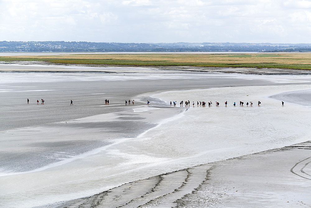 People walking on the sand during low tide, Mont-Saint-Michel, Normandy, France, Europe