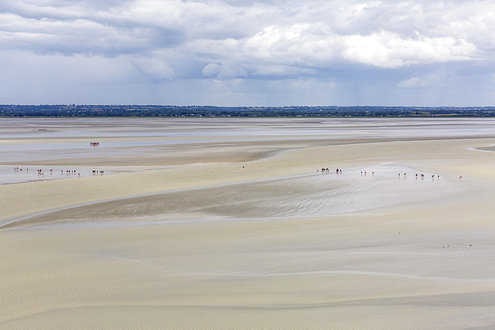 People walking on the sand during low tide, Mont-Saint-Michel, Normandy, France, Europe