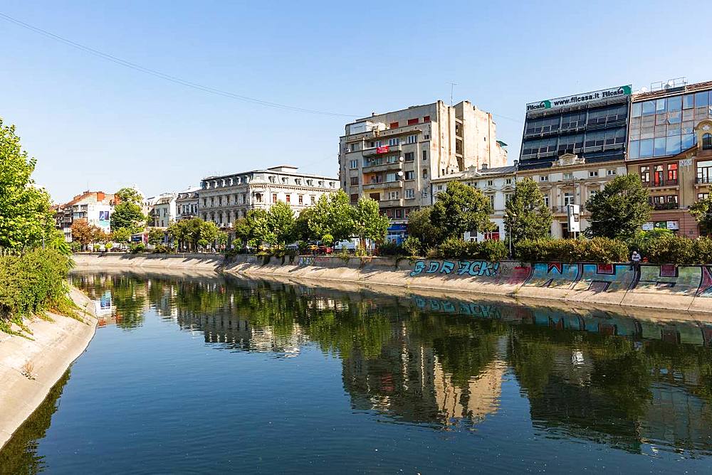 Communist era buildings reflected in the Dimbovita River in Bucharest, Romania, Europe