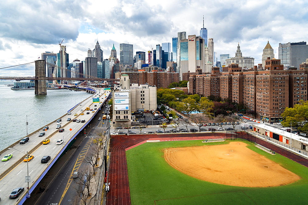 A baseball field along the FDR and East River with views towards the Brooklyn Bridge and Lower Manhattan, New York, United States of America, North America