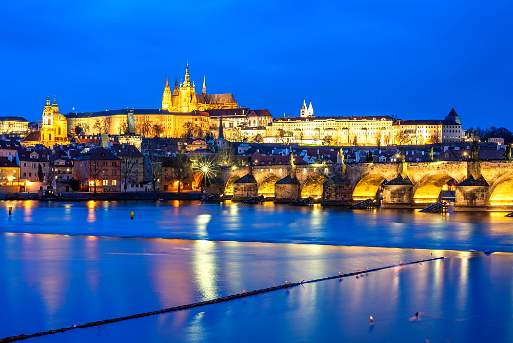 St. Vitus Cathedral and Prague Castle lit up during the evening blue hour reflecting in the Vltava River, UNESCO World Heritage Site, Prague, Czech Republic, Europe