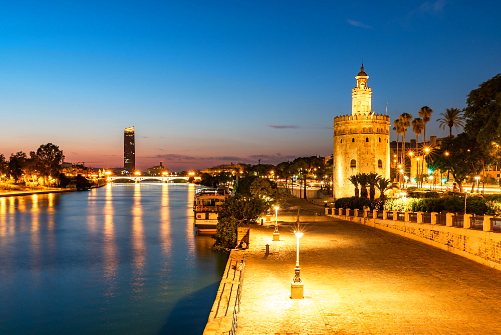 Sunset at Torre del Oro (Tower of Gold), a watchtower on the bank of the Guadalquivir River in Seville, Andalusia, Spain, Europe