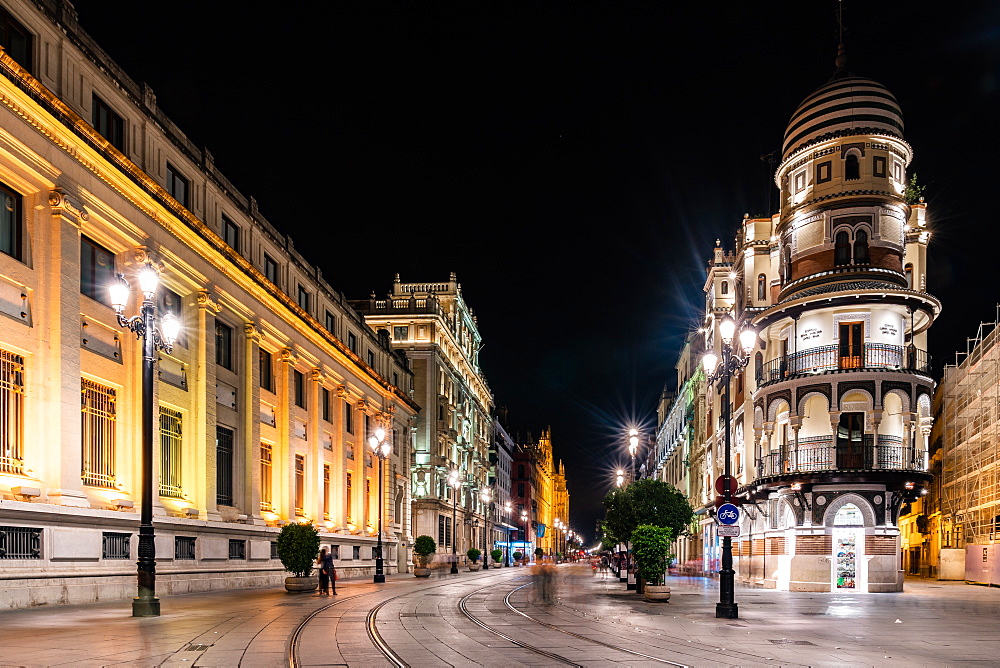 The lights of Seville's buildings at night looking down the Avenida de la Constitucion towards the Catedral de Sevilla, Seville, Andalusia, Spain, Europe