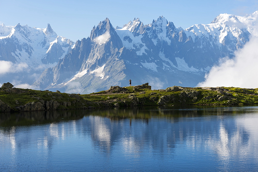 Hikers reflected in Lake Cheserys, Mont Blanc, French Alps, France, Europe