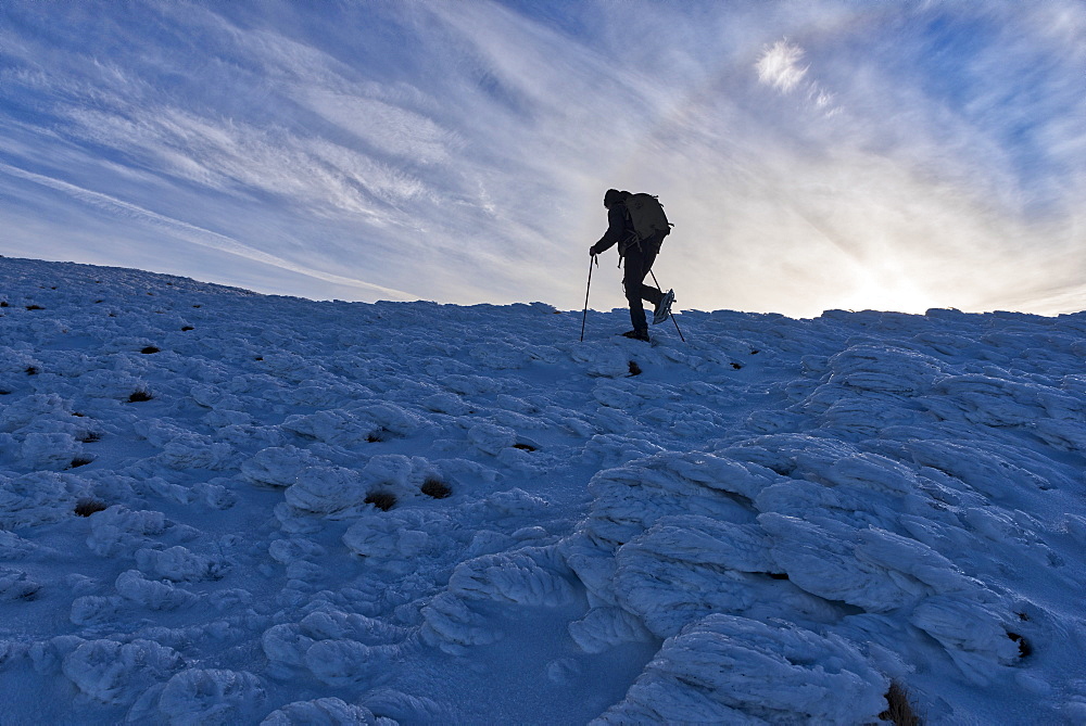 Hiker at sunrise in winter, Monte Cucco Park, Apennines, Umbria, Italy, Europe