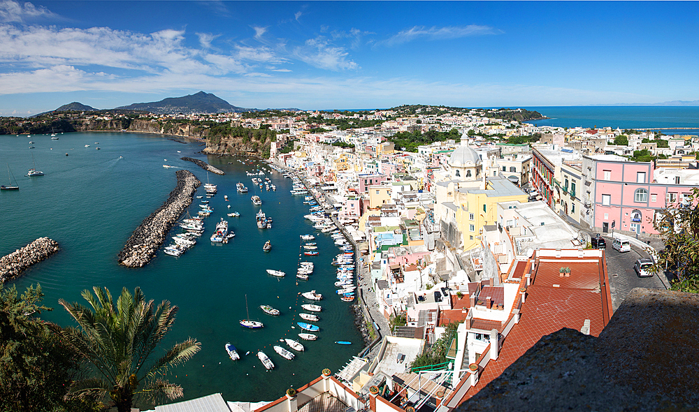 panoramic view of Coricella town, sea and castle on beautiful Procida island with colorful houses in sunny summer day Italy