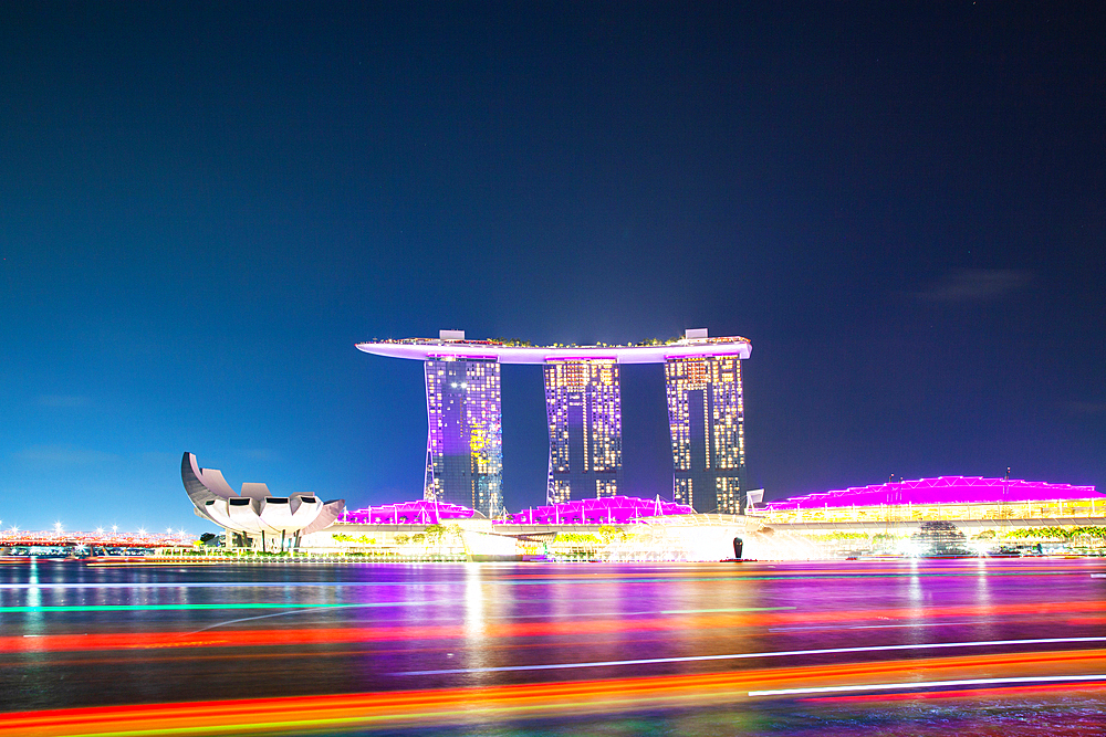 SINGAPORE, SINGAPORE - MARCH 2019: Skyline of Singapore Marina Bay at night with Marina Bay sands, Art Science museum and tourist boats