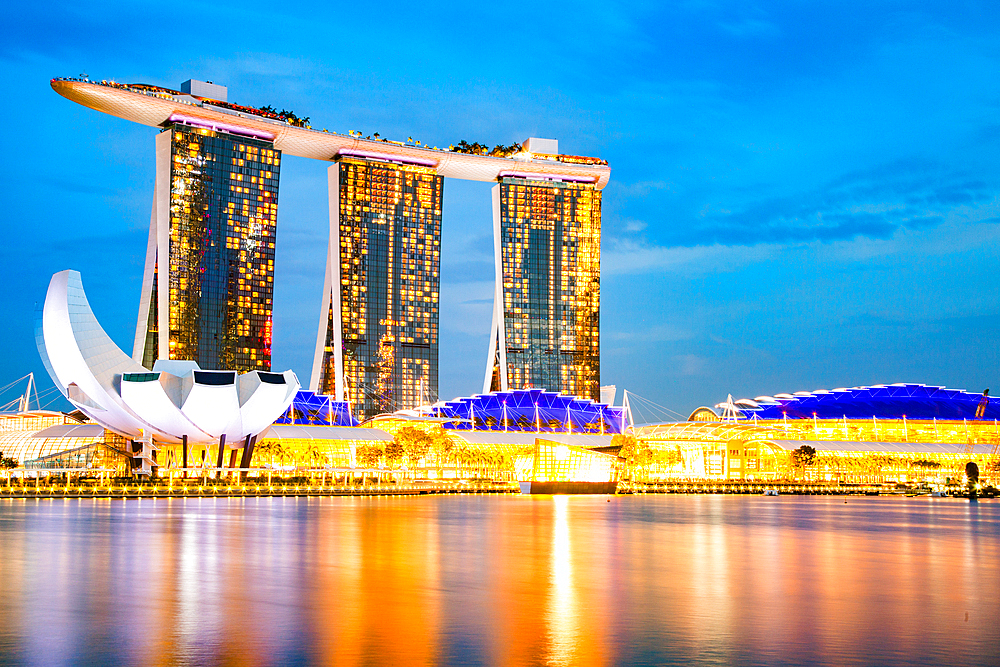 SINGAPORE, SINGAPORE - MARCH 2019: Skyline of Singapore Marina Bay at night with Marina Bay sands, Art Science museum and tourist boats