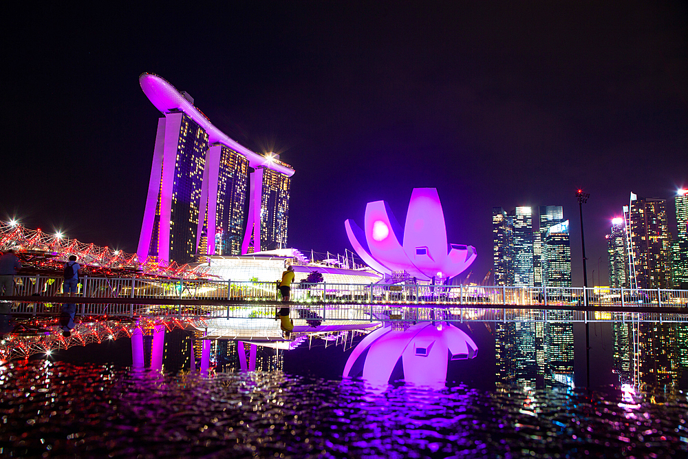 SINGAPORE, SINGAPORE - MARCH 2019: Skyline of Singapore Marina Bay at night with Marina Bay sands and Art Science museum reflecting in a pond after rain. Vibrant night scene