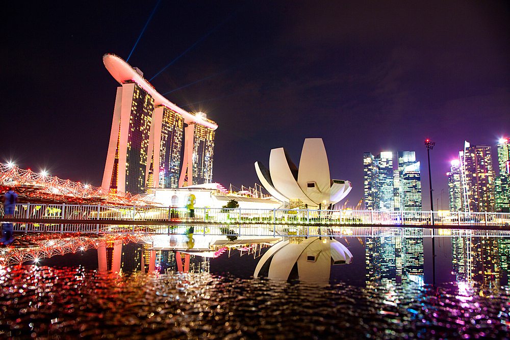 SINGAPORE, SINGAPORE - MARCH 2019: Skyline of Singapore Marina Bay at night with Marina Bay sands and Art Science museum reflecting in a pond after rain. Vibrant night scene