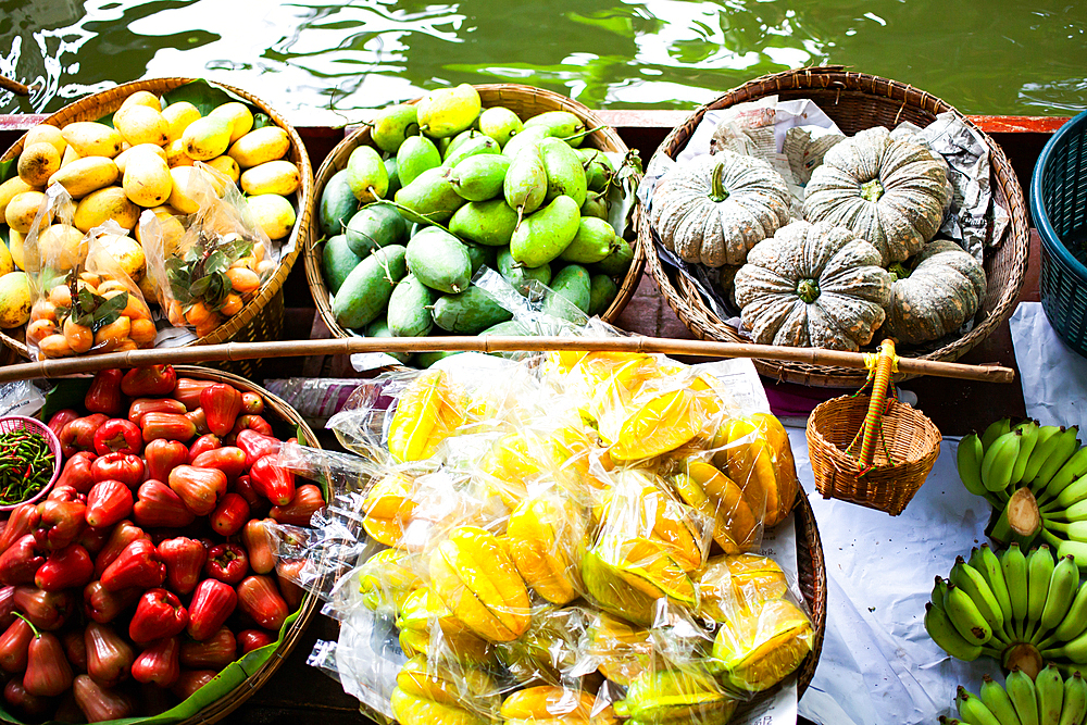 floating market - top view of boat full of fresh fruits on sale