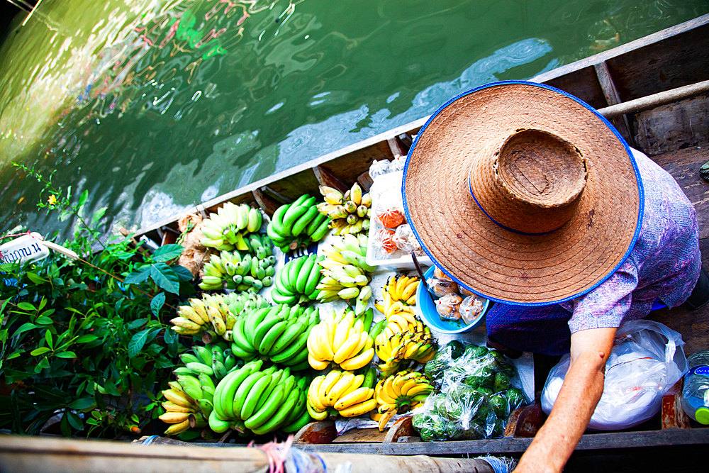 floating market - top view of boat full of fresh fruits on sale