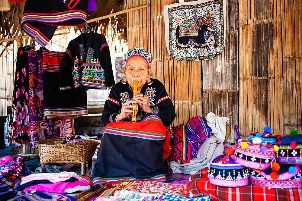 Hmong woman sewing in her home in Baan Tong Luang eco village near Chiangmai,Thailand.Hill tribe people live from selling their handicrafts to tourists.