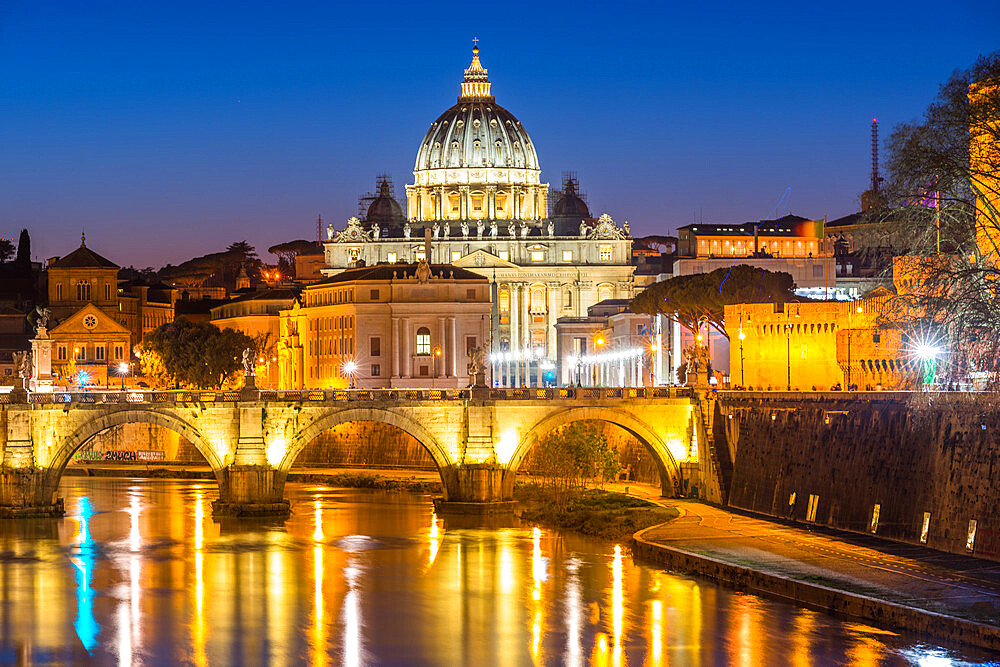 St. Peters Basilica and the Vatican with Ponte St Angelo over river Tiber illuminated at dusk, Rome, Lazio, Italy, Europe