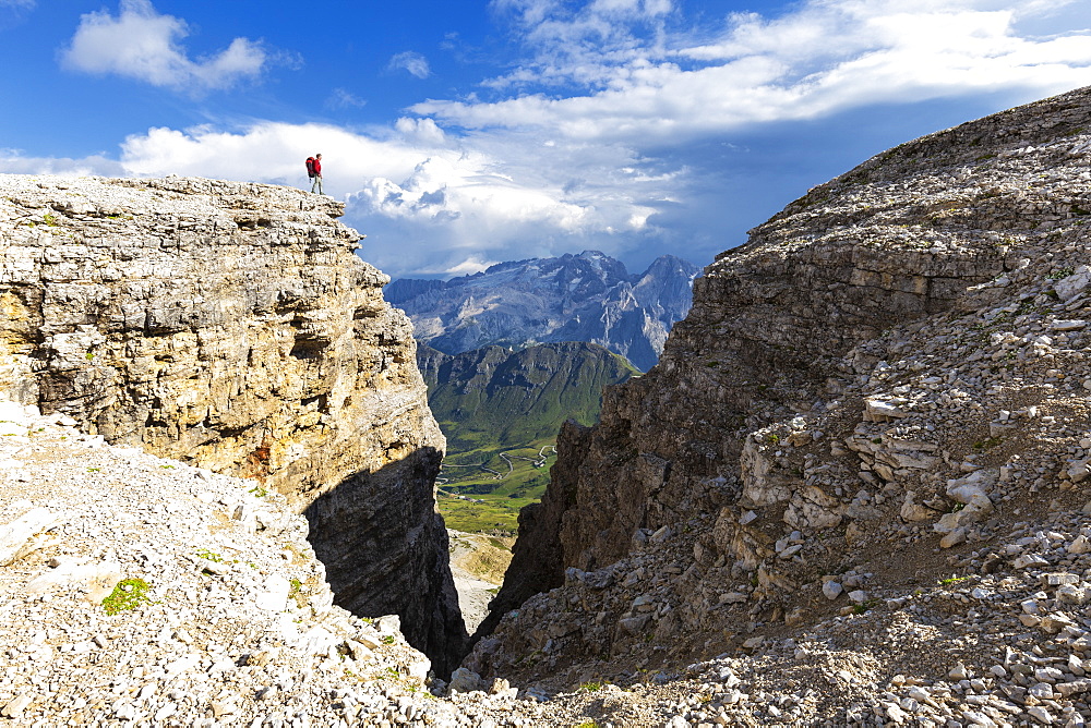 Hiker looks towards Marmolad, Piz Pordoi, Pass Pordoi, Fassa Valley, Trentino, Dolomites, Italy, Europe