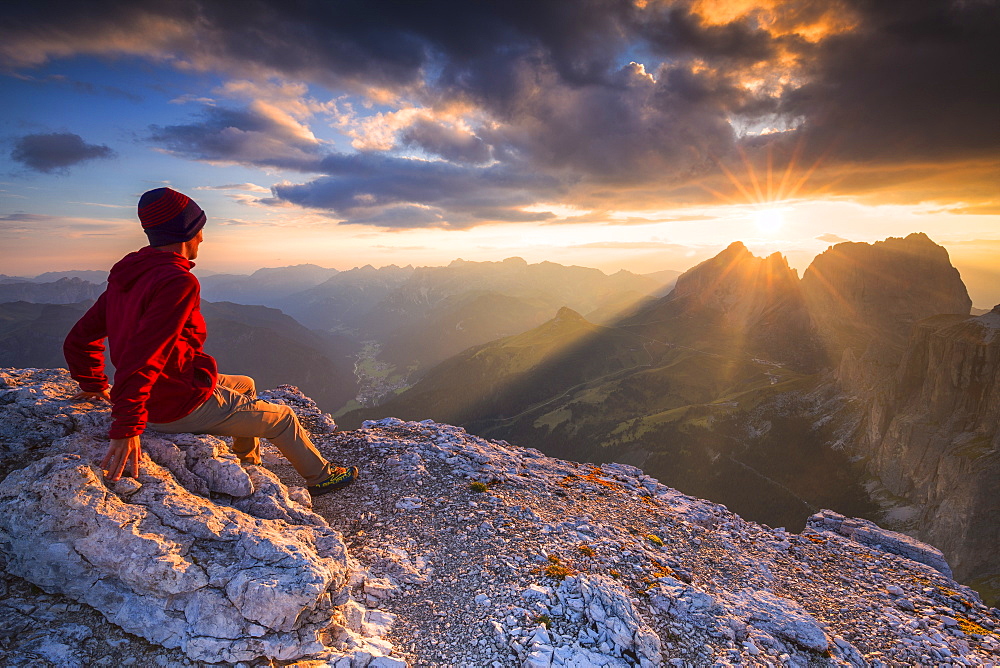 Hiker looks at sunset from Piz Pordoi, Fassa Valley, Trentino, Dolomites, Italy, Europe