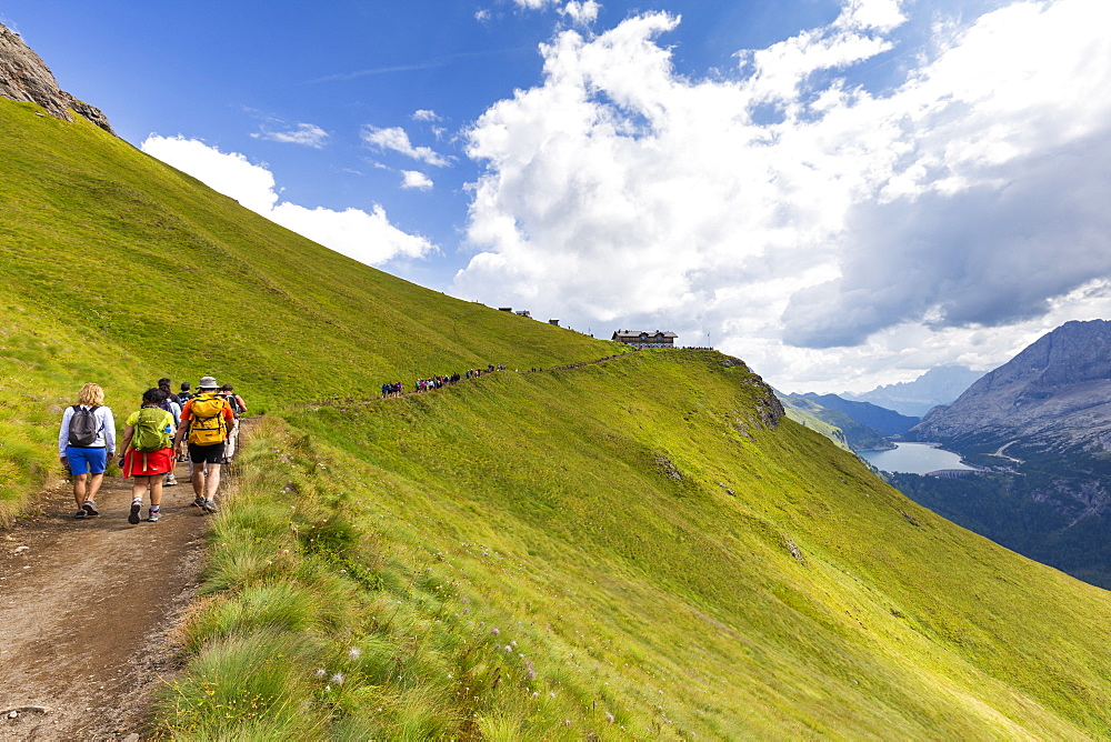 Hikers walk on Viel del Pan Path near Pordoi Pass, Fassa Valley, Trentino, Dolomites, Italy, Europe