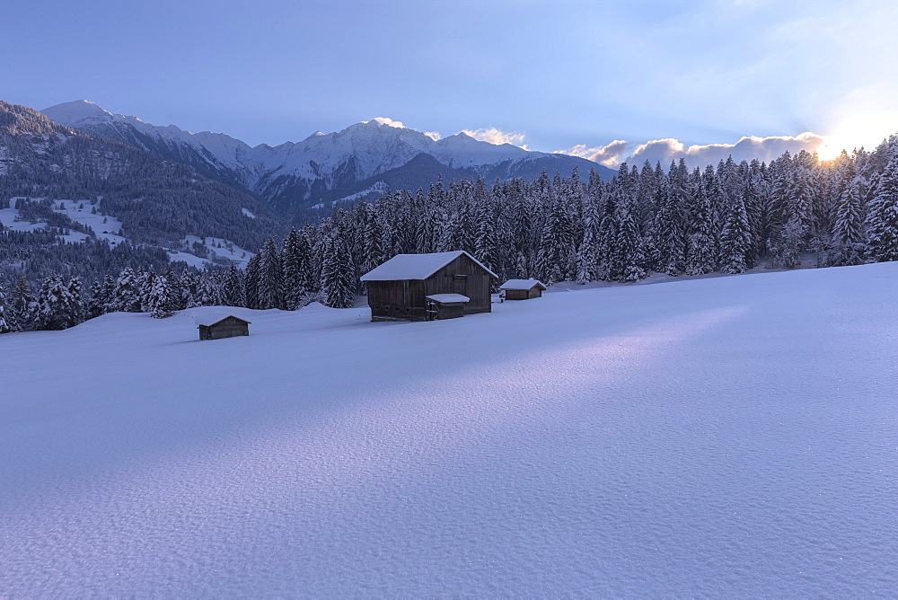 The sun sets behind the trees, Tuora, Flims, Imboden, Graubunden, Switzerland, Europe