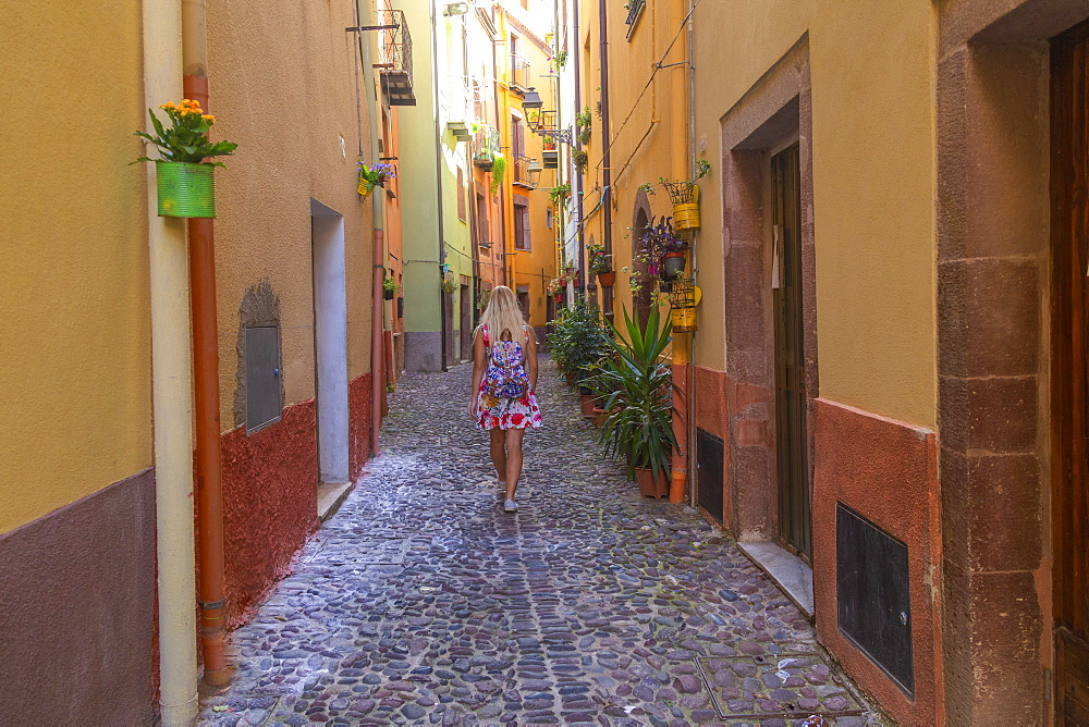 A girl walks in a street of Bosa, Oristano province, Sardinia, Italy, Mediterranean, Europe