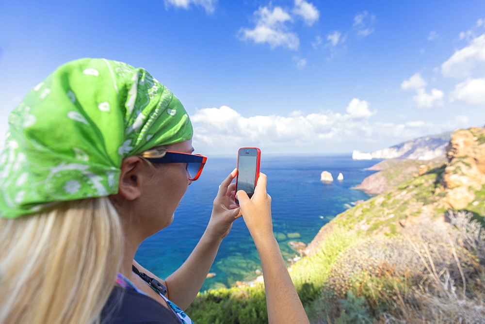 A tourist takes a photo with smartphone, Nebida, Iglesias, Sud Sardegna province, Sardinia, Italy, Mediterranean, Europe