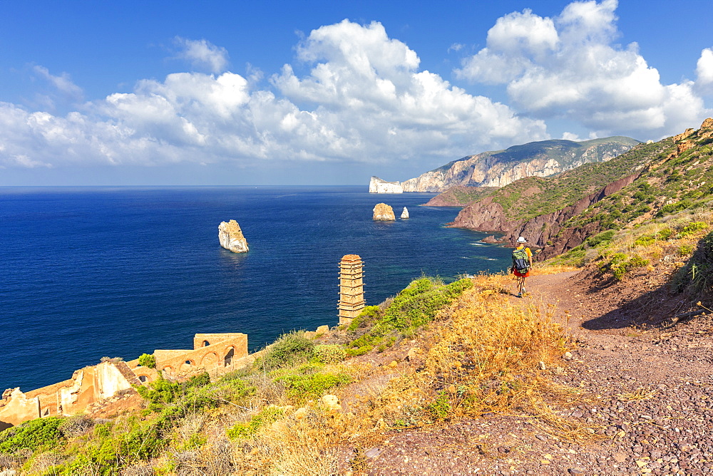 A tourist walks on a path to Laveria Lamarmora, Nebida, Iglesias, Sud Sardegna province, Sardinia, Italy, Mediterranean, Europe