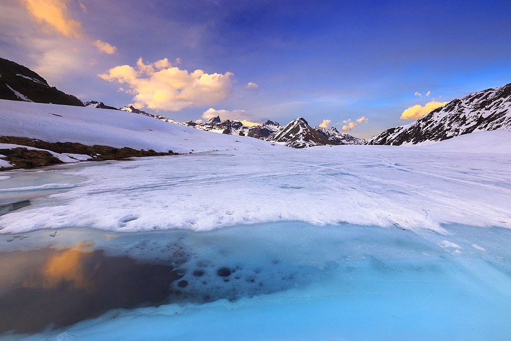 Sunset during thaw at the Malghera Lake, Valtellina, Lombardy, Italy, Europe