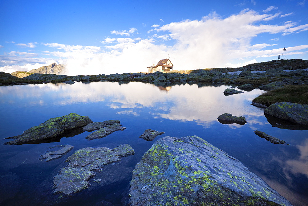 Benigni Refuge reflected with fog in the lake, Val Brembana, Lombardy, Italy, Europe