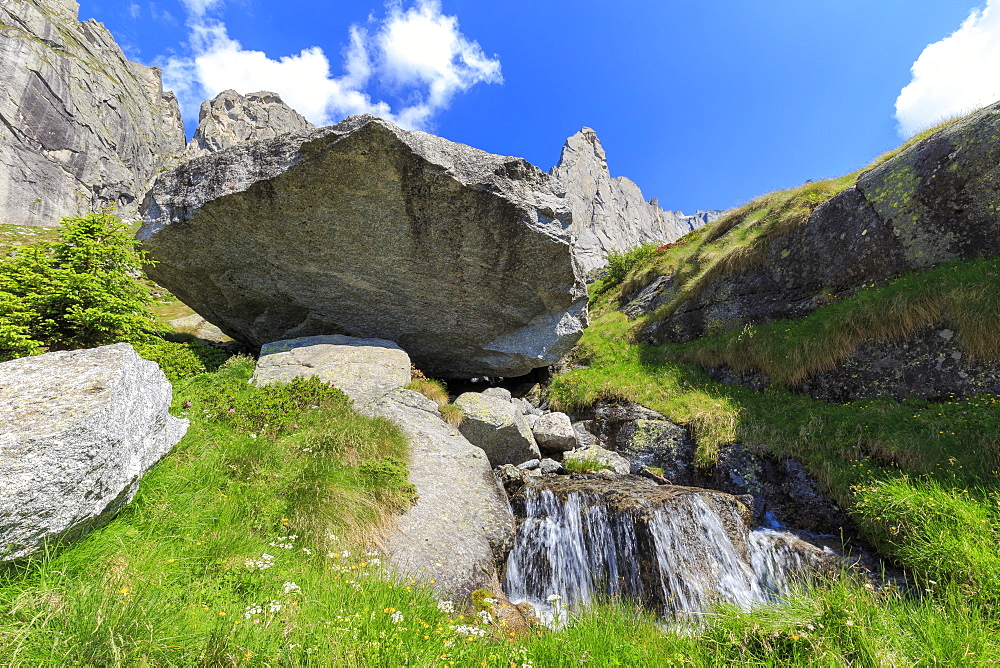 Balancing rock and torrent in Torrone Valley, Valmasino, Valtellina, Lombardy, Italy, Europe