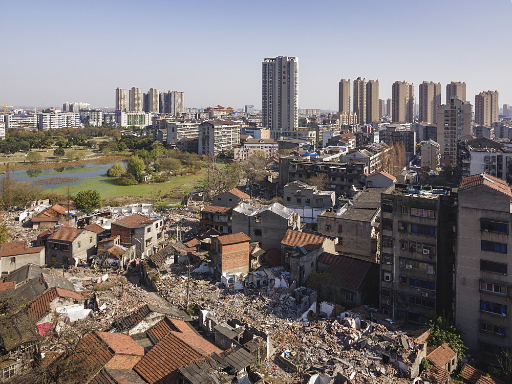 Tall buildings rise behind torn down old apartment buildings, Jingzhou, Hubei, China, Asia