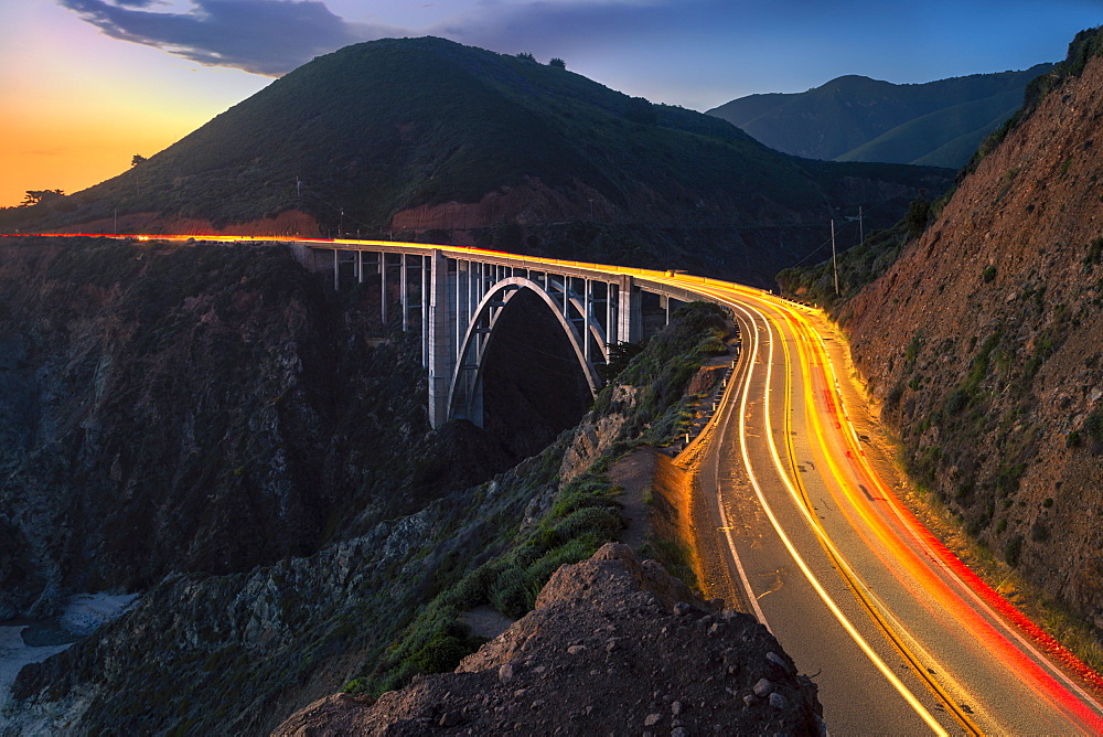 Sunset over Bixby Creek Bridge and car trail lights, Big Sur, California, United States of America, North America