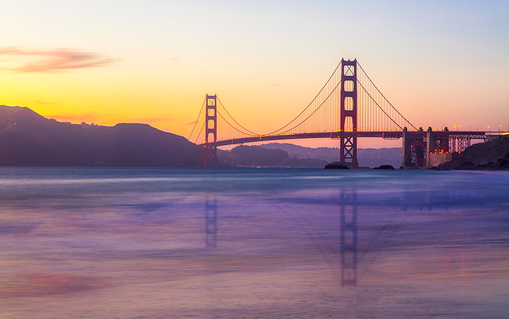 Soft flowing water reflects the beautiful Golden Gate Bridge at sunset, San Francisco, California, United States of America, North America