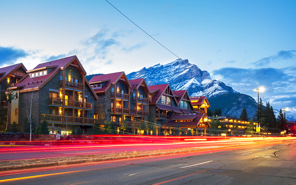 Trail lights on Banff Avenue and mountains in background at dusk, Banff, Banff National Park, Alberta, Canada, North America