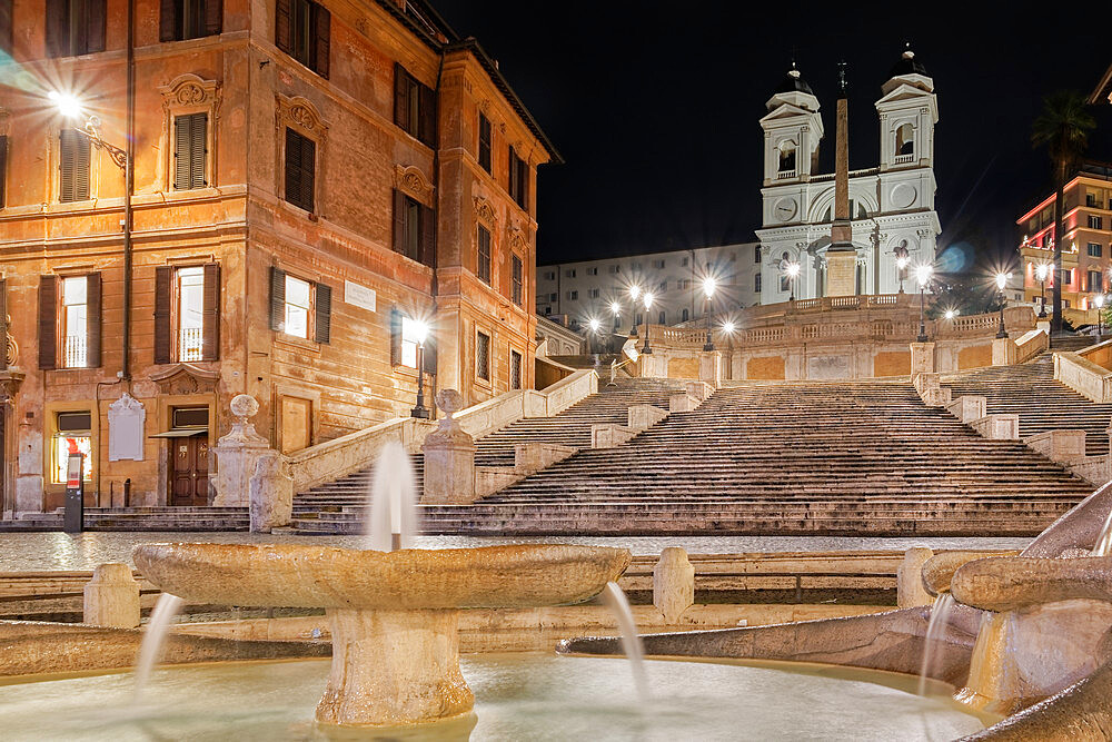 Illuminated night view of Piazza di Spagna with empty Spanish Steps, Barcaccia Fountain and Trinita dei Monti church, Rome, Lazio, Italy, Europe