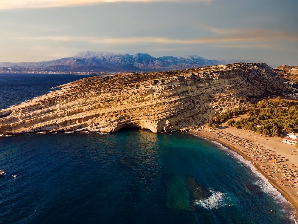 Drone view of Matala artificial caves on the rock by the beach at Crete, Greek Islands, Greece, Europe