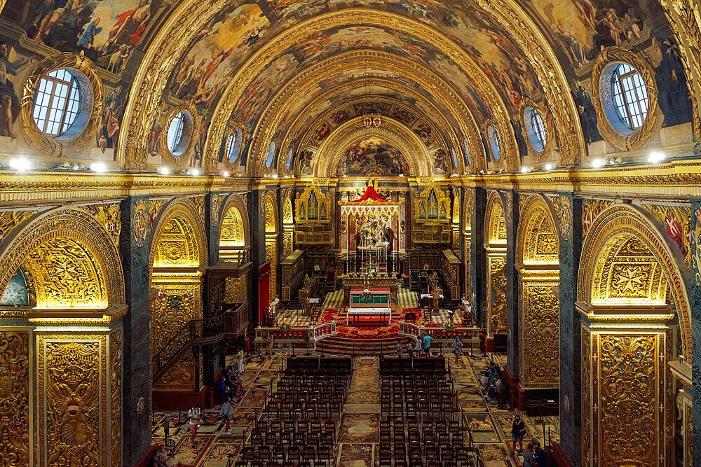 Panoramic interior view of Roman Catholic St. John Co-Cathedral with golden Maltese cross symbols on arches, Valletta, Malta, Europe