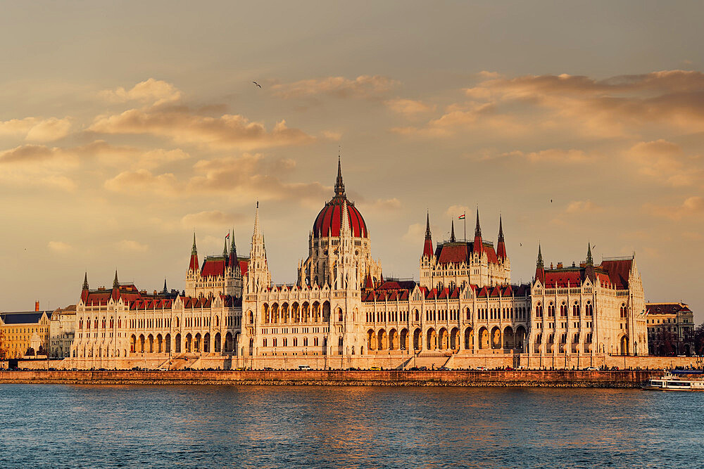 Orszaghaz Parliament neo-Gothic building and River Danube view at sunset, with clouds above, UNESCO World Heritage Site, Budapest, Hungary, Europe