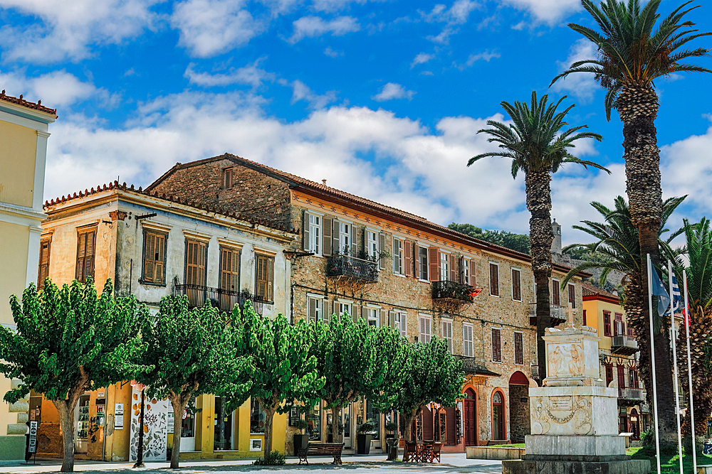 Central square Trion Navarchon (Three Admirals), with memorial and traditional low-rise houses against a blue sky with clouds, Nafplion, Peloponnese, Greece, Europe