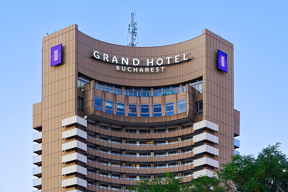 Low angle view of Grand Hotel Bucharest skyscraper with logo, under a clear blue sky, Bucharest, Romania, Europe