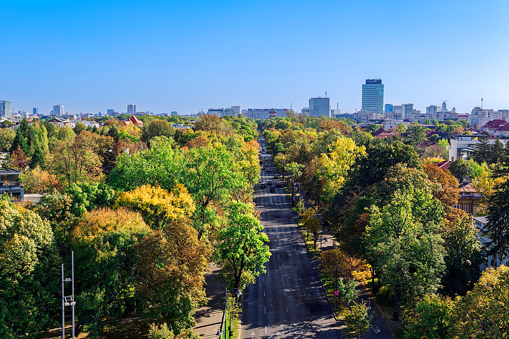 Panoramic city view with park and modern buildings in the background under a clear blue sky, Bucharest, Romania, Europe