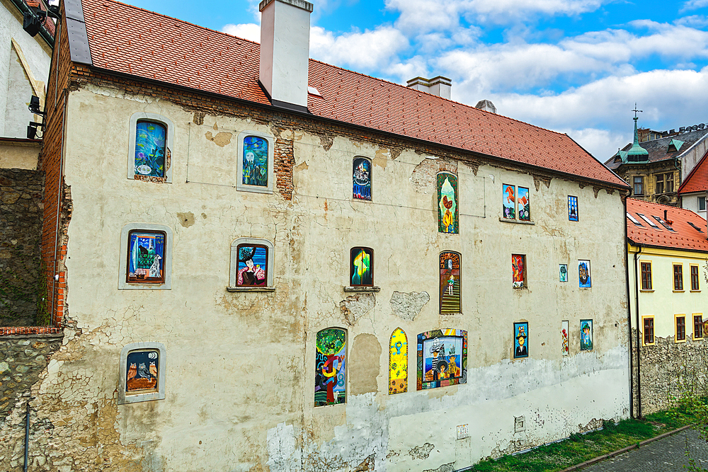 Vivid graffiti on the windows and wall of an old house with roof tiles, Bratislava, Slovakia, Europe