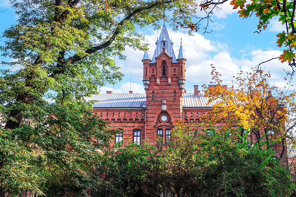 Low angle of traditional building of Municipal Headquarters of the State Fire Service surrounded by trees, Krakow, Poland, Europe