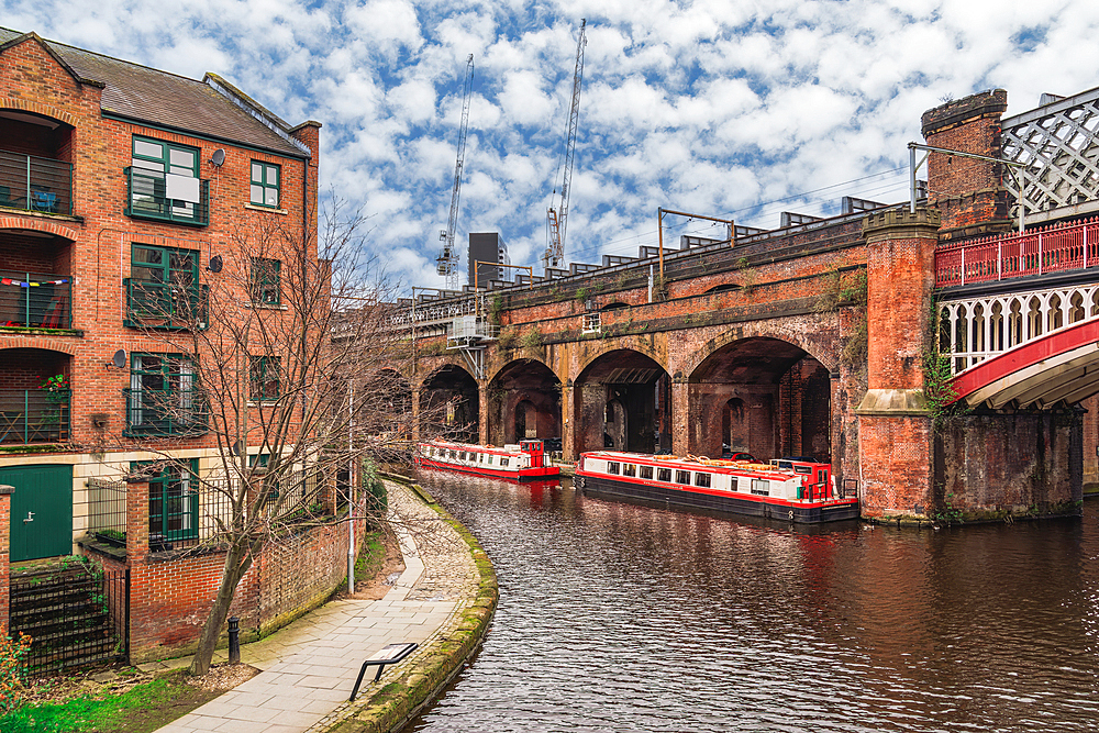 Castlefield neighbourhood canals with moored cruise narrowboats on the waterfront, Manchester, England, United Kingdom, Europe